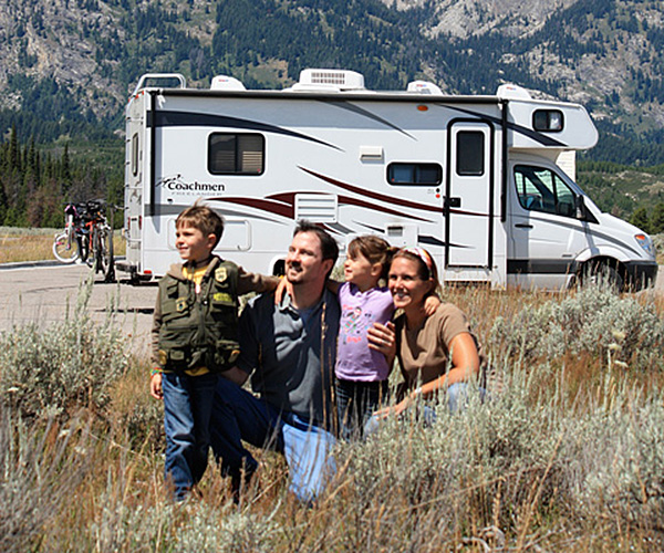 A family next to a class c motorhome.