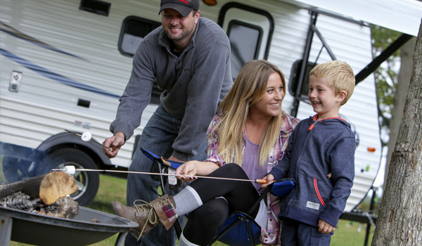Family grilling in front of a Travel Trailer